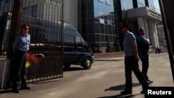 FILE - Interior Ministry officers stand at the entrance to the Investigative Committee of the Russian Federation compound in Moscow, June 15, 2012. 