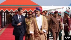 President Bashar al-Assad, left, is welcomed by Oman's Sultan Haitham bin Tariq al-Said in Muscat, Feb. 20, 2023, in this handout picture released by the official Syrian Arab News Agency.