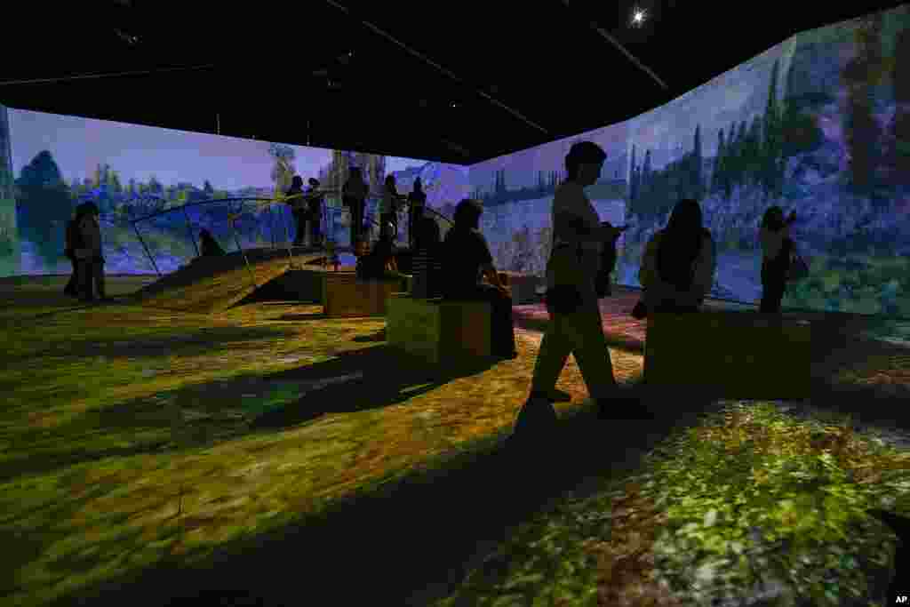 People visit an immersive, multimedia exhibit titled "Monet by the Water," about the work of France's painter Claude Monet (1840-1926), at Bicentenario Park in Santiago, Chile.