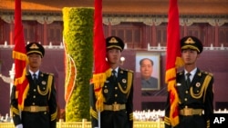 FILE - A Chinese honor guard stands near a portrait of former Chinese leader Mao Zedong on Tiananmen Gate near Tiananmen Square before a welcome ceremony for Niger's President Mahamadou Issoufou at the Great Hall of the People in Beijing, May 28, 2019.