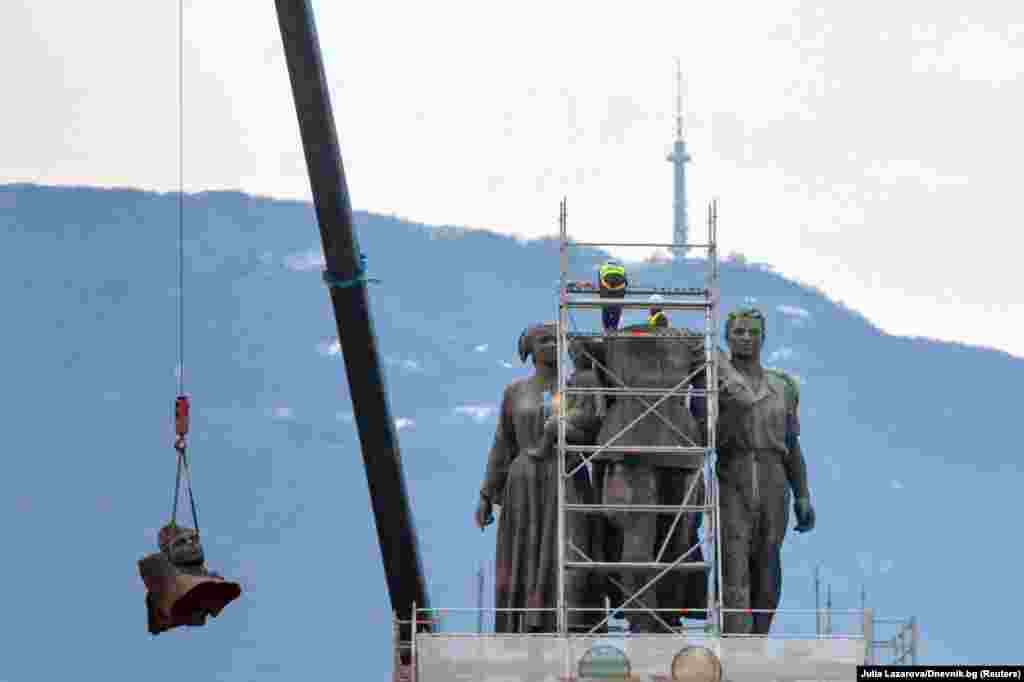 Workers take apart the main sculpture of the Soviet army monument in central Sofia, Bulgaria.