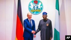 In this photo released by the Nigeria State House, German Chancellor Olaf Scholz, left, is welcomed by Nigeria's President Bola Tinubu, upon his arrival at the Presidential Palace in Abuja, Nigeria, Oct. 29, 2023.