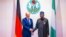 In this photo released by the Nigeria State House, German Chancellor Olaf Scholz, left, is welcomed by Nigeria's President Bola Tinubu, upon his arrival at the Presidential Palace in Abuja, Nigeria, Oct. 29, 2023.