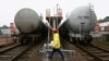 FILE - A worker walks past trains transporting oil tanks in Suining, Sichuan province, March 2, 2009. Talks reportedly have resumed after pandemic-related delays about a railway project in Myanmar to connect China's Yunnan province to the Bay of Bengal.