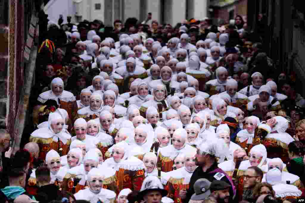 Revelers dressed as a &quot;Gilles,&quot; the oldest and principal participants in the Carnival of Binche in Belgium, take part in the parade in Binche, Belgium.