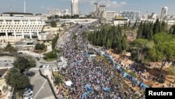 Pandangan dari udara menunjukkan warga Israel memegang bendera dalam aksi demo di depan Knesset, parlemen Israel di Yerusalem, 13 Februari 2023. (REUTERS/Ilan Rosenberg)