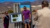 Tourists pose for a photo next to a thermometer displaying a temperature of 132 degrees Fahrenheit/55 degrees Celsius at the Furnace Creek Visitors Center, in Death Valley National Park, Calif., July 7, 2024. 
