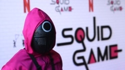 Seseorang berpakaian seperti karakter dari acara tersebut terlihat di acara FYSEE "Squid Game", Minggu, 12 Juni 2022 di Netflix FYSEE di Raleigh Studios di Los Angeles. (Foto: AP)