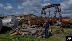 Ukrainian farmer Valerii Shkuropat checks ammunition shells found on his farm in Ivanivka, Kherson region, April 25, 2023. 