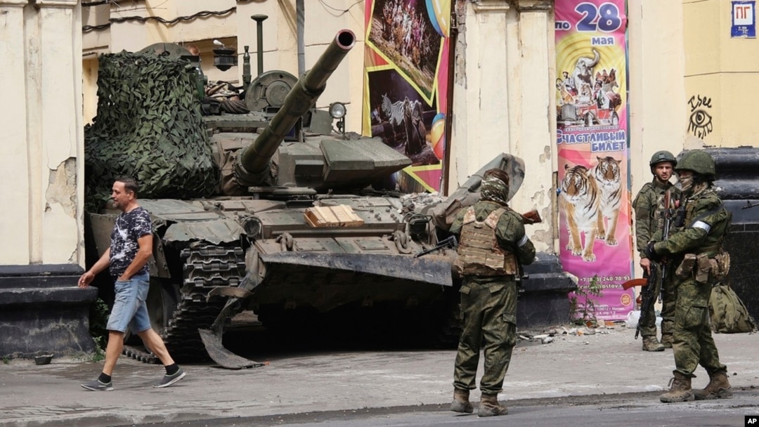 Russian servicemen guard an area standing in front of a tank in a street in Rostov-on-Don, Russia, June 24, 2023. 