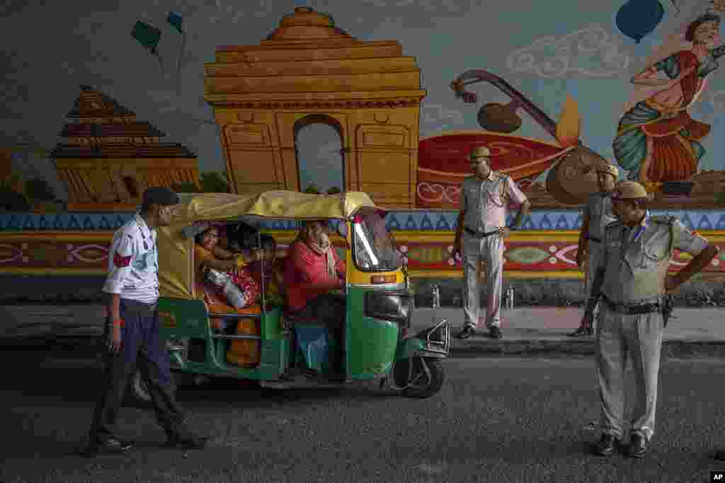 Policemen stop an auto rickshaw at a checkpoint as traffic restrictions and diversions are placed ahead of the weekend's G-20 Summit, in New Delhi, India.