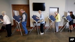 FILE - Voters fill the electronic voting machines to cast their ballots during the primary election at the precinct in the Highland Colony Baptist Church in Madison, Miss., on Tuesday, March 8, 2016. (AP Photo/Rogelio V. Solis)
