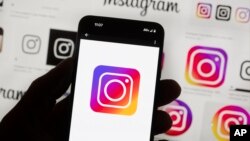 FILE - The Instagram logo is seen on a cellphone, Oct. 14, 2022, in Boston. Google, Facebook, TikTok and other Big Tech companies operating in Europe are facing one of the most far-reaching efforts to clean up what people encounter online.