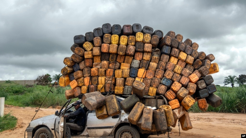 A driver carrying empty plastic containers pauses on his way to buy fuel from Angola and sell it back in Muanda, western Democratic Republic of Congo, Dec. 23, 2023. 