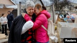 Local resident Svetlana Boiko, who was injured in recent shelling, is comforted by her acquaintance Yulia Kryukova while standing near her destroyed house in the course of Russia-Ukraine conflict in Donetsk, Russian-controlled Ukraine, March 12, 2023. 