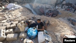 Palestinians inspect the site of an Israeli strike on a house, amid the conflict between Israel and the Palestinian Islamist group Hamas, in Rafah, in the southern Gaza Strip, May 8, 2024.