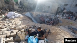 Warga Palestina memeriksa sebuah rumah yang hancur akibat serangan Israel di Rafah, di selatan Jalur Gaza, pada 8 Mei 2024. (Foto: Reuters/Mohammed Salem)