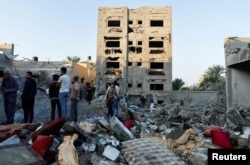 Warga Palestina melihat hancurnya sebuah rumah pasca serangan di tengah konflik dengan Israel di Khan Younis, di selatan Jalur Gaza, 12 Oktober 2023. (Foto: REUTERS/Ibraheem Abu Mustafa)