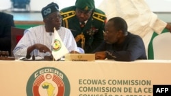 FILE — ECOWAS Chairperson and President of Nigeria, Bola Ahmed Tinubu interacts with President of ECOWAS Commission Omar Touray, during the ECOWAS Head of States and Government extraordinary session in Abuja, on August 10, 2023. 