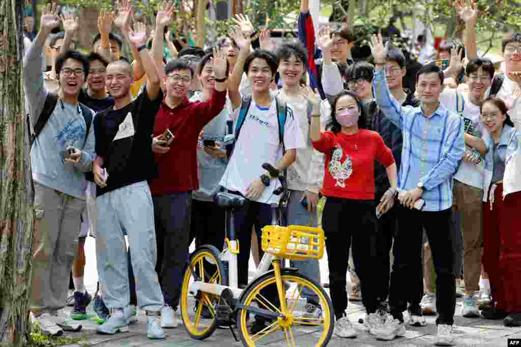 Chinese students wait for the arrival of French President Emmanuel Macron at Sun Yat-sen University in Guangzhou, China.