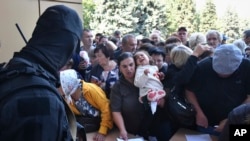 Personas evacuadas en la región de Kursk hacen cola para llenar formularios de ayuda humanitaria en un centro de distribución de ayuda en Kursk, Rusia, el 14 de agosto de 2024.