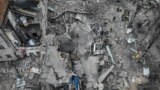 2024年3月25日，救援人员在乌克兰基辅一处遭到导弹袭击的现场展开工作。（法新社照片）