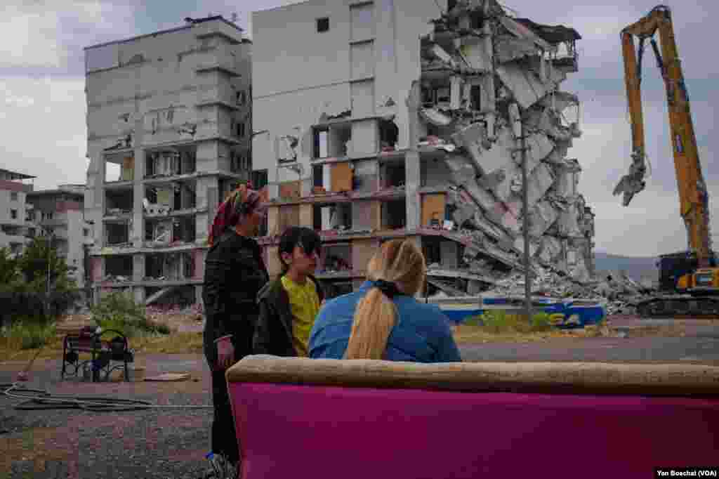A family watches their heavily damaged building be demolished three months after they evacuated during the earthquake that killed more than 50,000 people. &ldquo;I left even without my shoes,&rdquo; says Sema, 27, in Nurdagi, Turkey, &nbsp;May, 11, 2023.
