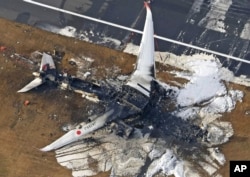 This aerial photo show the burn-out Japan Airlines plane at Haneda airport on Wednesday, Jan. 3, 2024, in Tokyo, Japan. (Kyodo News via AP)