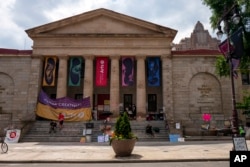 FILE - Signs and writing denouncing the closure of the University of the Arts are pictured at Dorrance Hamilton Hall on Friday, June 14, 2024, in Philadelphia. (AP Photo/Joe Lamberti)