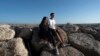 Siblings Sofia Oliveira, 18, and Andre Oliveira, 15, pose for a picture at the beach in Costa da Caparica, south of Lisbon, Sept. 20, 2023. 