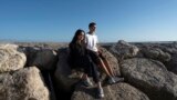 Siblings Sofia Oliveira, 18, and Andre Oliveira, 15, pose for a picture at the beach in Costa da Caparica, south of Lisbon, Sept. 20, 2023. 