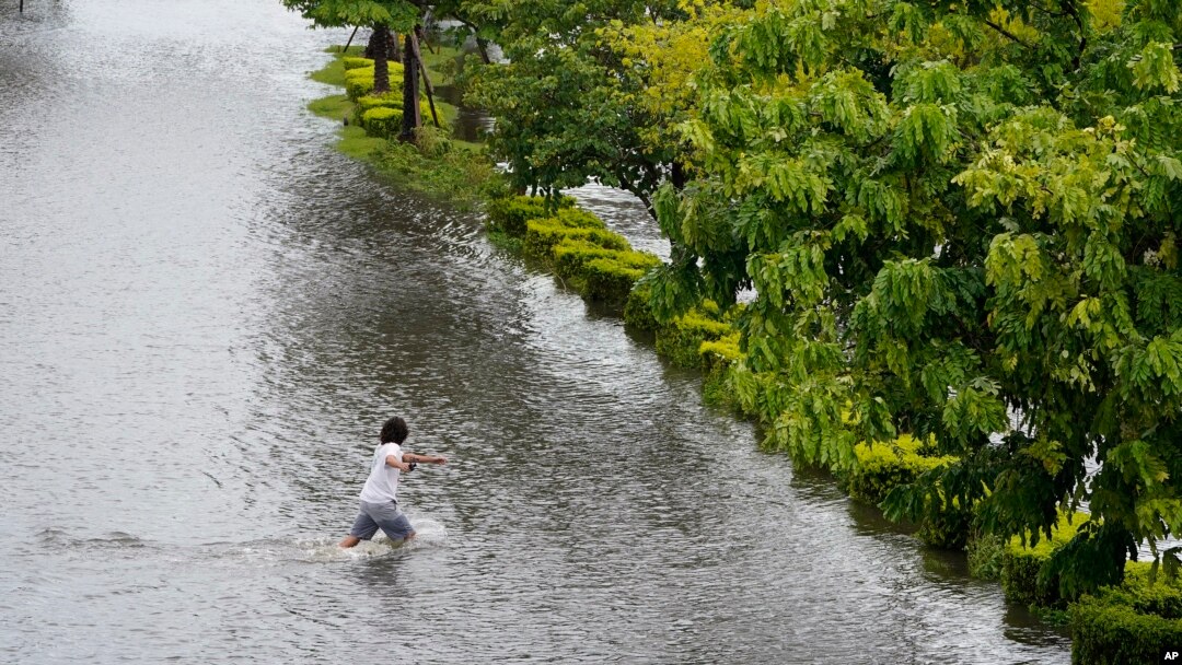 A man runs across Bayshore Boulevard, which was flooded from the storm surge associated with Hurricane Idalia, on Aug. 30, 2023, in Tampa, Florida. Idalia made landfall earlier Wednesday morning along the Big Bend of the state.