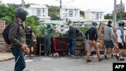 Masked residents set up roadblocks to block access and channel pro-independence activists at the entrance to Tuband, in the Motor Pool district of Noumea, New Caledonia, May 15, 2024.