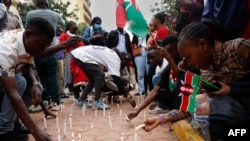 Des jeunes kenyans allument des bougies à la mémoire des manifestants tués, à Nairobi, le 30 juin 2024.