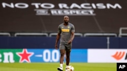 FILE - Inter Milan's Romelu Lukaku walks in front of a "no to racism" banner during a training session on Aug. 4, 2020. A U.N.-backed committee expressed concern on Aug. 31, 2023, that no legal cases have been brought in Italy to punish fans for racist acts at sports events.