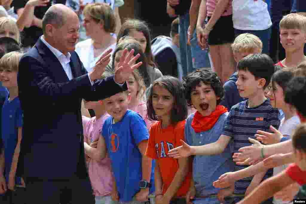 Германскиот канцелар Олаф Шолц со децата за време на неговата посета на основното училиште Ајгенхерд за да го одбележи денот на проектот на ЕУ во училиште, во Клајнмахнов, Германија.