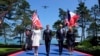 U.S. President Joe Biden walks with U.S. first lady Jill Biden, right, French President Emmanuel Macron, second from left, and his wife, Brigitte Macron, during ceremonies to mark the 80th anniversary of D-Day in Normandy, June 6, 2024. 