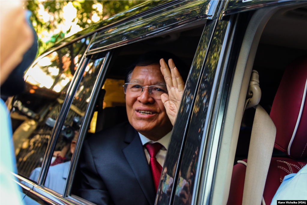 រូបឯកសារ៖ លោក កឹម សុខា អតីតមេដឹកនាំគណបក្សសង្គ្រោះជាតិ លើកដៃស្វាគមន៍ក្រុមអ្នកសារព័ត៌មាន ខណៈលោកចាកចេញពីគេហដ្ឋានរបស់លោក មុនសេចក្តីប្រកាសសាលក្រមកាត់ក្តីរូបលោកពីបទក្បត់ជាតិ នៅរាជធានីភ្នំពេញ ថ្ងៃទី ៣ ខែមីនា ឆ្នាំ ២០២៣។ (កាន់ វិច្ឆិកា/វីអូអេ)