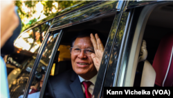 Kem Sokha, mantan pemimpin Partai Penyelamat Nasional Kamboja, melambaikan tangan kepada para wartawan saat meninggalkan rumahnya untuk menghadiri putusan pengadilan di Phnom Penh, pada Jumat, 3 Maret 2023. (Kann Vicheika, VOA Khmer)