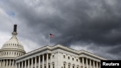 FILE - A cloud hangs over the US House of Representatives in Washington, Oct. 17, 2023.