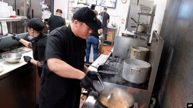 FILE - Tito Thepkaysone cooks up some Pad Thai at Love & Thai restaurant in Fresno, Calif. on Dec. 20, 2023.