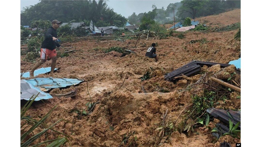 Warga meninjau lokasi longsor yang melanda sebuah desa di Pulau Serasan, Kabupaten Natuna, Senin, 6 Maret 2023. (BNPB via AP)