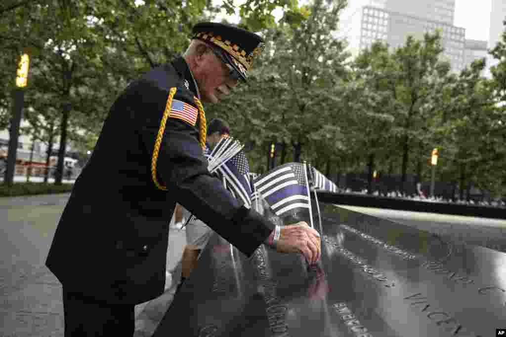 Sam Pulia coloca banderas antes de la ceremonia conmemorativa de los ataques terroristas del 11 de septiembre de 2001, el lunes 11 de septiembre de 2023, en Nueva York.&nbsp;