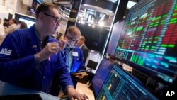 Specialist Patrick King, left, works at his post on the floor of the New York Stock Exchange, Aug. 6, 2024.