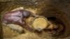 FILE - Miners extract mud at a gold mining site where adults and youth work in Uganda, Oct. 18, 2021. As the race to acquire economically vital minerals unfolds, those in Africa’s mining sector are calling to protect the women and children laborers who keep it running. 