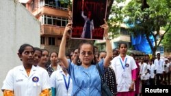 Para dokter dan petugas kesehatan membawa poster dan meneriakkan slogan-slogan selama aksi protes di Mumbai, India, mengecam pemerkosaan dan pembunuhan seorang dokter magang di Kolkata, Minggu 18 Agustus 2024.