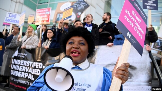 FILE - A person uses a megaphone as nurses protest during a strike by NHS medical workers, amid a dispute with the government over pay, outside University College London Hospital in London, Britain, Feb. 6, 2023.