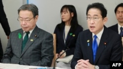 日本首相岸田文雄在星期五一場政策會議上講話，日本國家公安委員長谷公一（左）坐在他身旁。（2023年4月28日）