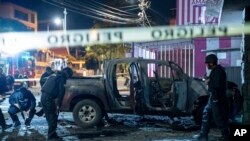 Police inspect a truck that exploded outside an office used by the government's National Service for Attention for People Deprived of Liberty (SNAI), which runs the jail system, in Quito, Ecuador, Aug. 31, 2023. 