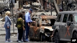 FILE - President Joe Biden and first lady Jill Biden look at a burned car with Hawaii Gov. Josh Green and his wife, Jaime Green, as they visit areas devastated by the Maui wildfires, Aug. 21, 2023, in Lahaina, Hawaii.